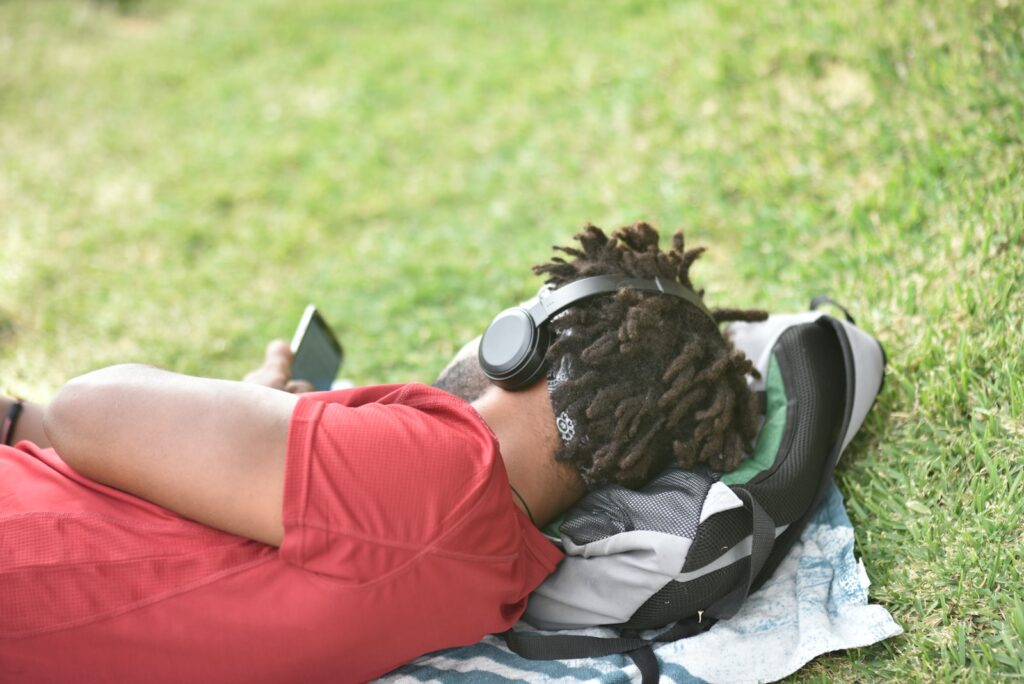 man laying on gray backpack